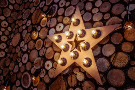Star with incandescent lamps. Retro light. A wooden star. Wood trim. Lighting of wooden finishes. Incandescent lamps.の写真素材