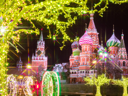 Happy New year greeting card. Garlands on the streets of Moscow. Christmas greetings from Russia. Luminous decor and the Moscow Kremlin. The Kremlin and St. Basil Cathedral on new year eve.のeditorial素材