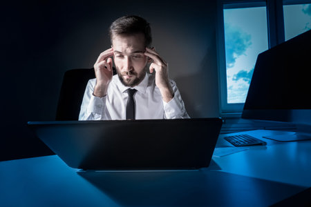 Tired worker. A tired businessman works in the evening. A man in office clothes is holding his...
