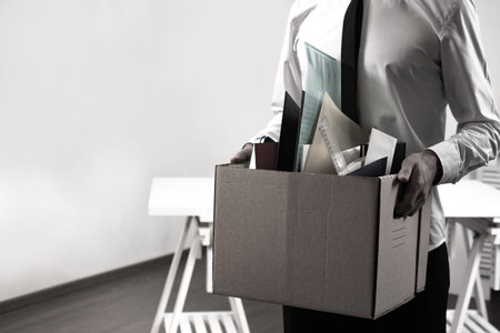 A man leaves the workplace with a box of office supplies. Dismissal from work. Loss of jobs. The...