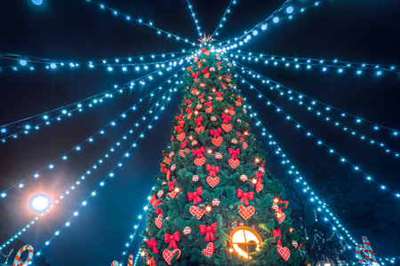 Christmas tree against a dark sky. The Christmas tree is decorated with toys and garlands. New year...