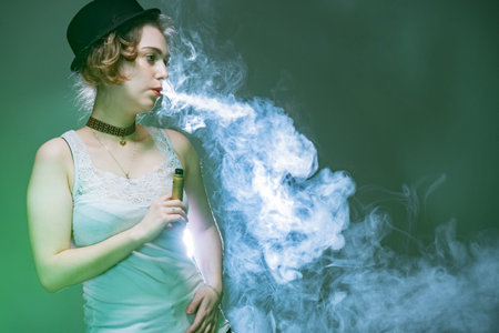 The girl in the hat is Smoking an electronic cigarette.