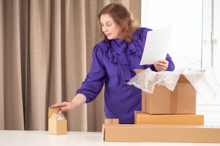 A businesswoman packs parcels to send to customers.
