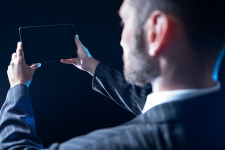 Electronic tablet in the hands of a man. A person holds a tablet in front of him and looks at the...