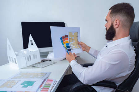 Design project of a new house. The designer is working on a cottage project. The architect selects the color scheme for the rooms. The man works as an interior designer.の写真素材