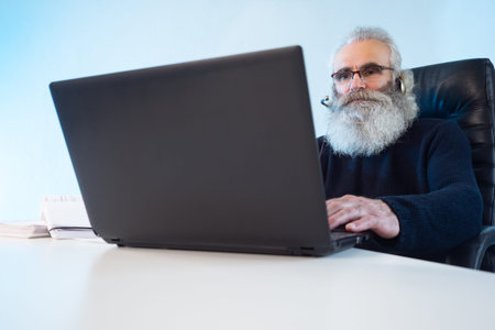 An elderly man works remotely. A bearded man works as an auditor. A person checks financial...