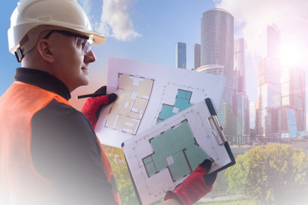 Civil engineer. A man in an orange vest and a white hard hat. Engineer with the layout of the...