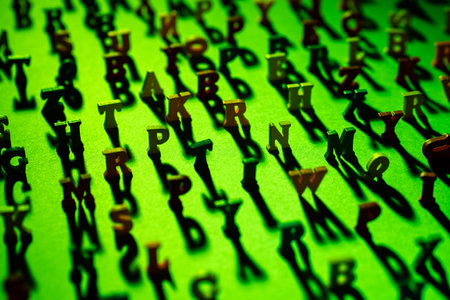 Latin letters stand on a green background and cast shadows. The letters of the alphabet in random...