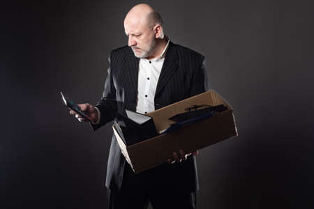 The man looks at the calculator. Dismissal from work. Loss of livelihood. Minimum consumption. The man lost his job. Unemployment. Crisis in the labor market.の写真素材