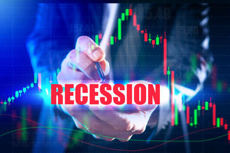 Economic indicators of the recession. A person looks at data on a tablet against the background of the word Recession. The red word is Recession and a declining graph.の写真素材