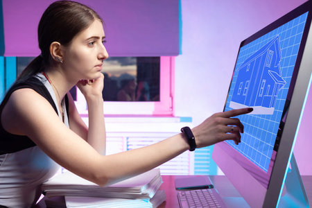 The girl is working on a project for a new house. Computer image of the future home. A woman...