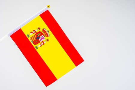 Spanish flag on a white background. Flag Of The Kingdom Of Spain. Red and yellow flag with the coat of arms of Spain. Official state symbol of Spain. Banners of the countries of the world.の写真素材