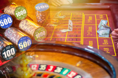 Casino. Roulette chips. Casino tokens and dollars on the table in the casino. People place money bets in the hope of winning. Gambling. Cash game.の写真素材