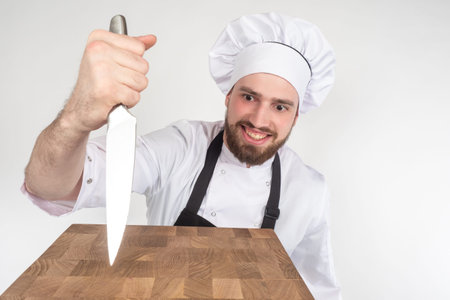 Culinary humor. The chef jokes and shows his bloodthirstiness. The chef sticks a knife into the...