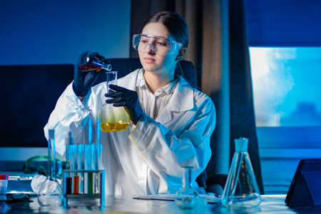 A chemistry student in the lab. Laboratory classes in chemistry. The girl conducts experiments with chemical liquids. The girl runs a blog on chemistry.の写真素材