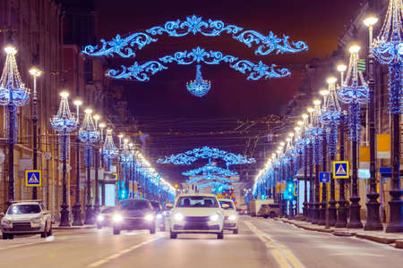 New Year Saint Petersburg. Cars go down the street decorated with garlands. Festive illumination on city street. Christmas in Russia. Winter evening in St. Petersburg.の写真素材