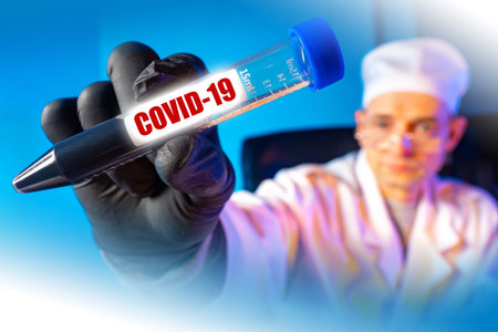 Analysis for coronavirus. The doctor shows a test tube with the inscription Covid-19. Control the...