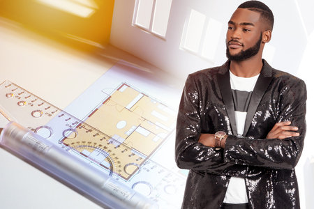 The project of a new house and a contented dark-skinned young man in a shiny jacket. Individual...