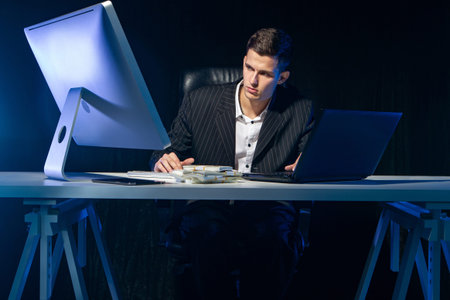 Successful businessman. Earnings on the Internet. Remote work. A man is sitting at a table with two...