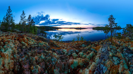 Panorama of a forest lake. Beautiful view of the lake and rocky shores. Mosses and lichens on the...