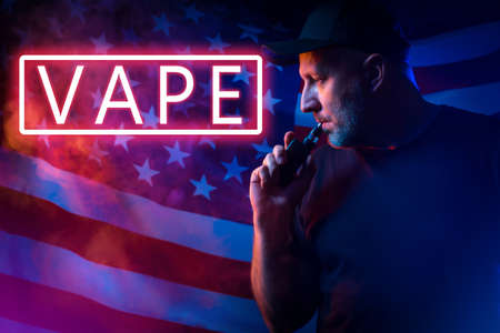 Neon sign VAPE and smoker on the background of the American flag. Vaping in the USA. American electronic cigarettes. Smoking electronic cigarettes in America.の写真素材