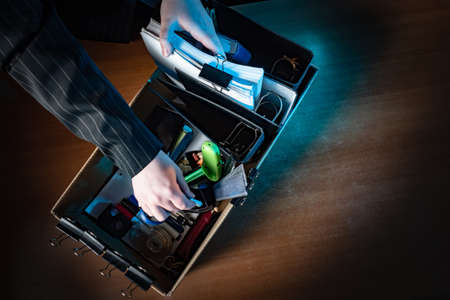 A box of office supplies as a symbol of job loss. Dismissal. Reduction of employees. Unemployment. Termination of business activities. Crisis. Bankruptcy.の写真素材