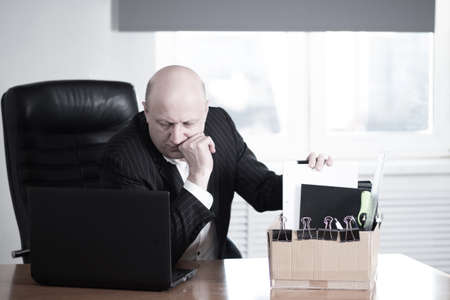 A frustrated entrepreneur looks at information on a laptop. The firm is on the verge of bankruptcy. The person is expecting to be dismissed from work. Bankruptcy of enterprises. Crisis. Job loss.の写真素材