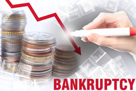 Bankruptcy. A critical drop in revenue. Red arrow down and the word Bankruptcy on the background of...