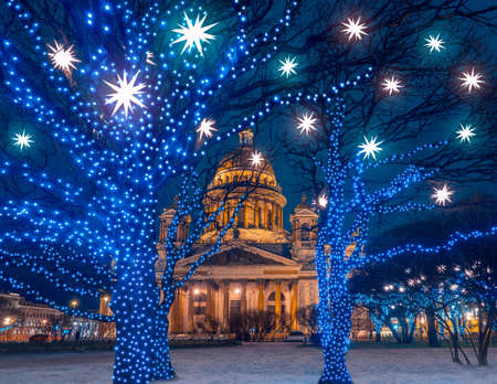 Saint-Petersburg on a winter evening. Festive Petersburg. Christmas in Russia. St. Petersburg is decorated for the New year. St. Isaac Cathedral in winter. Trees with garlands on city streets.の写真素材