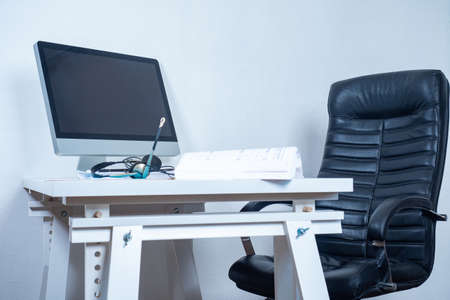 Empty workplace. A chair and a table with a laptop. Home office. Break in work. Desktop in the office. A place for office work.の写真素材