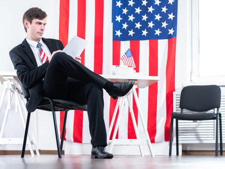 Lobbying USA. Man in a suit sits at table. Man in a row with American flags. Concept - man works as...