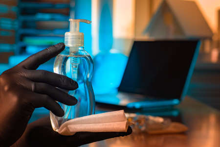 Antiseptic in the hands of man. Hand cleaning fluid. Hands of a man in gloves. Concept - office treatment by a sanitizer. Clearing rooms from bacteria. Concept - cleaning with an antiseptic.の写真素材
