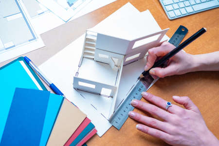 An architect creates a house plan. Hands of an architect close up. Woman draws a plan for the layout of the building. Create thumbnail-based drawings. Concept - working day of an architect.の写真素材