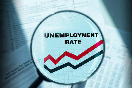 Unemployment rate graph is increasing. Inscription unemployment rate under a magnifying glass....