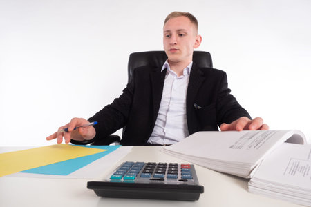 Auditor. Man in office is studying documents. Young guy in a business suit. Man sits office desk....
