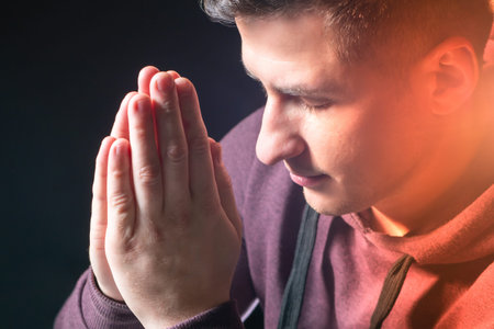 A Christian prays. The young man folded his hands in front of him and turned to God. Communion with...