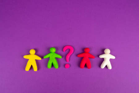 Figures of people from plasticine. Different colors of people show no racial discrimination. No skin color discrimination. A question mark symbolizes problems. Pink background. Problem discriminationの写真素材