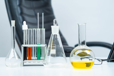 Transparent test tubes on background of empty chair. Laboratory glass on table. Concept - use of...