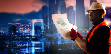 Architect nafone night down town. Builder with architectural drawings. Concept - he designs layout...