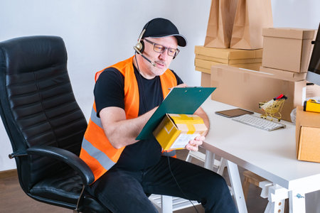 Owner shop at workplace. Man with a parcel in his hands is writing something down. Concept - small...
