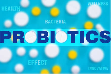 Probiotics logo on background of multi-colored tablets. Concept - treatment with probiotics bacteria. Innovations in field of probiotics. Treatment a person with beneficial bacteria. Wellness.の写真素材