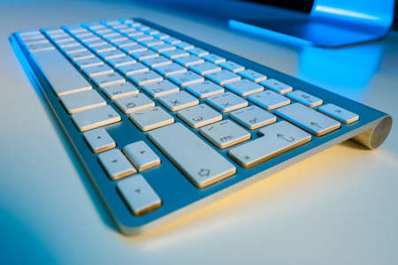 Stationary computer keyboard close up. Keyboard on white table. Gray keyboard with Russian layout. Cyrillic keys. Russian keys. Concept - sale of components for computers. Sale office equipmentの写真素材