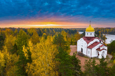 Landscape of Karelia. Churches of Russia. Church of St. George Victorious in Karelia. Orthodox church in autumn forest. Temple on background of sunset. Nature near Ruskeala Park. Forest in Russia.の写真素材