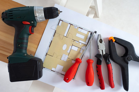 Builder tools on a white background. Architectural drawings next to construction tool. Screwdriver and screwdrivers lie side by side. Concept - things of repairman. Home renovation tools.の写真素材