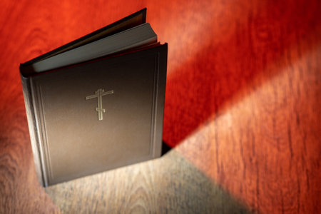 The Bible stands open on the table in the light. Reading the word of God. Christian religion. Religious literature. The concept of religion and faith. Study of the Holy Scriptures.の写真素材