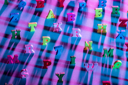 Alphabet letters in random order. Multi-colored letters are on table. Pink background. Letters are blurred and out of focus at edges Concept - education in English. English-language literature.の写真素材
