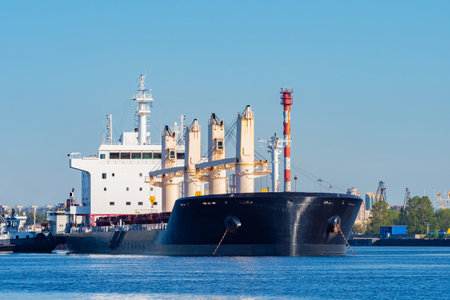 Huge bulk carrier moored at the port. Sea vessel for the transport of goods. Balker near the shore on a summer day. Marine ship for coal transportation. Ship for transporting coal. Ocean.の写真素材