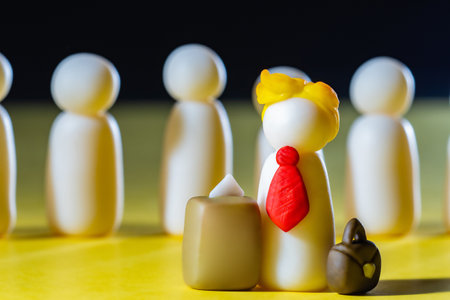 A man with a yellow haircut next to the ballot box. The ballot box symbolizes voting. Plasticine people on a dark background. Voter is like President of USの写真素材