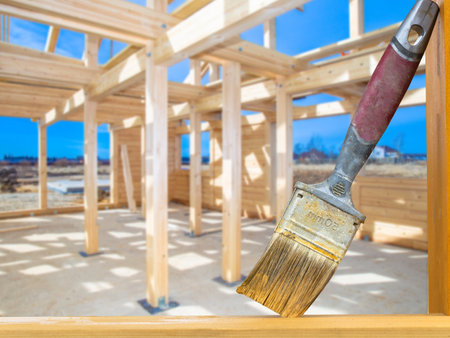 Varnishing of wooden beams. Brush for coating wood with varnish. Concept - impregnation of frame from termites. Against termite painting of beams. Concept - sale of construction brushes. Constructionの写真素材
