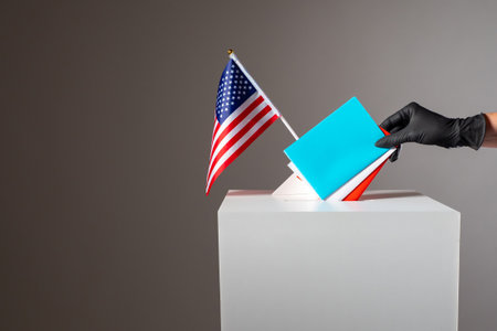 Voter hand in a medical glove. Hand putting voting paper with US flag. Voting concept - presidential election during danger of infection. US presidential election during quarantine. Several ballots.の写真素材